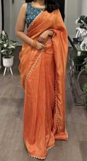 Picture of Orange tissue saree with contrast peacok color blouse